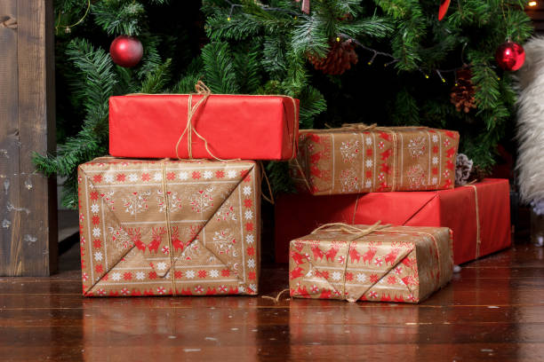 istock Red gift boxes near the christmas tree during christmas celebration. 879261062