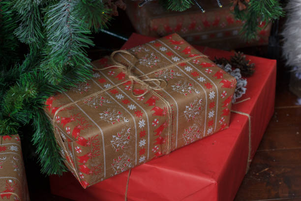 istock Red gift boxes near the christmas tree during christmas celebration. 879261698
