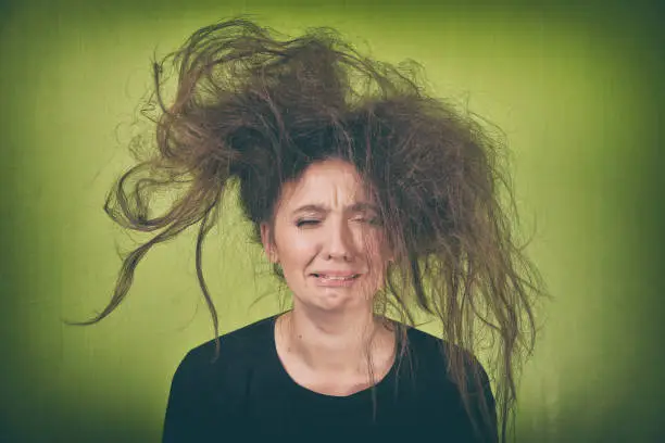 angry woman with a strange hair style on a green background