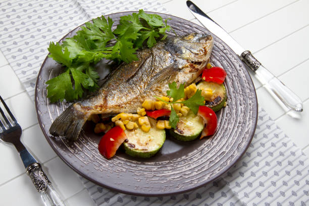 istock Baked sea bream with celery, zucchini, bell pepper and corn 879276794