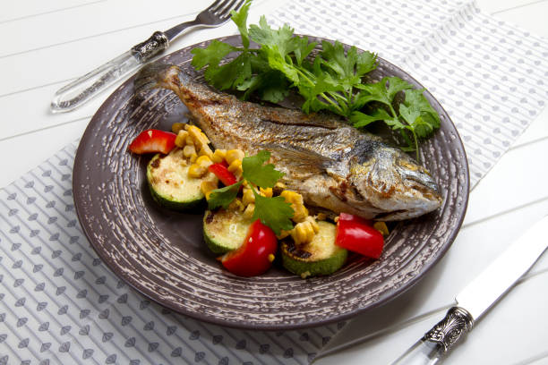 istock Baked sea bream with celery, zucchini, bell pepper and corn 879276850