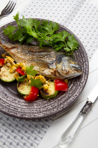 istock Baked sea bream with celery, zucchini, bell pepper and corn 879276880