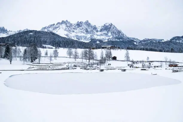 Wilder Kaiser mountainrange with snow with frozen lake during winter, Going am Wilden Kaiser, Tyrol, Austria