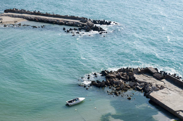 Two breakwaters and a boat in the bay look from the air