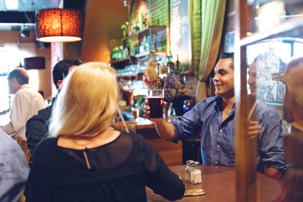 Coworkers having an happy hour in a bar, happy hour time