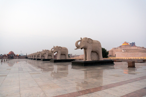 Statues of elephants placed in a straight line in the famous landmark Ambedkar Park of Lucknow. The red sandstone work and beautiful reflective floor add to the beauty