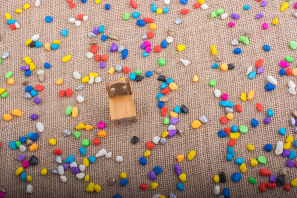 istock Little chair amid colorful pebbles spread on canvas background 879290470
