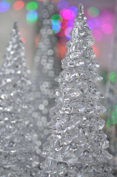 istock Decorative glass Christmas tree on a background of colorful lights. 879290744