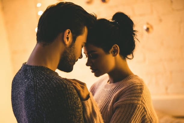 passionate romantic couple in sweaters are spending time together before new year at home. - romance sensuality couple bed imagens e fotografias de stock