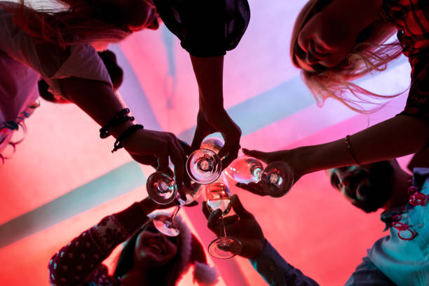 クリスマス パーティーにシャンパンのグラスを持つ若い人々 - 政党 ストックフォトと画像
