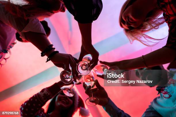 Young People With Glasses Of Champagne At Christmas Party Stock Photo - Download Image Now