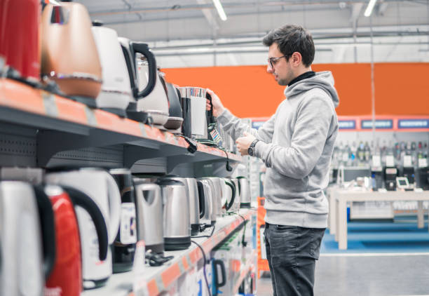 customer chooses a kettle in supermarket mall