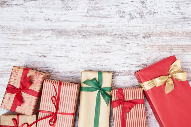 istock Wrapped gifts boxes decorated with ribbon on  wooden background. Copy space, top view 879322014