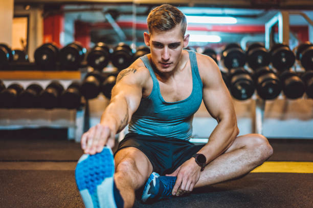 istock Muscular athlete stretching in the gym 879326742