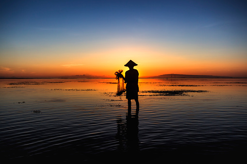 Fisherman silhouette at sunrise. Bali, Indonesia