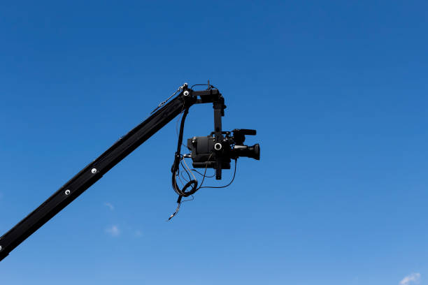 istock Professional Video Camera Attached To Jib Against Blue Sky 879348670