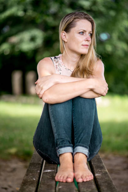 istock Woman Sitting on Bench Looking Away 879359028
