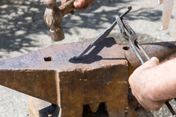 istock blacksmith works the iron with anvil and hammer 879361110