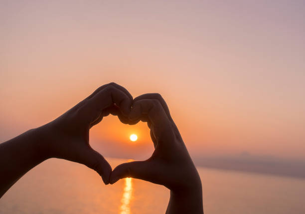 istock Heart shaped hands at sunrise 879380506