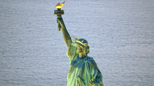 AERIAL Statue of Liberty with lit torch in the evening
