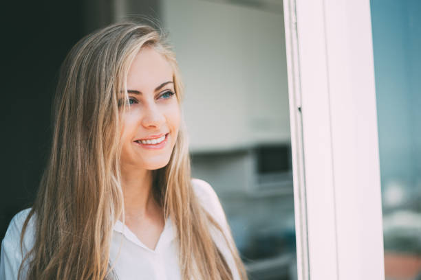 istock Young thoughtful woman looking through the window 879402060