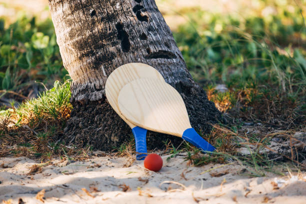 beach tennis, beach paddle ball, matkot. racchette da spiaggia e palla sulla spiaggia - matkot foto e immagini stock