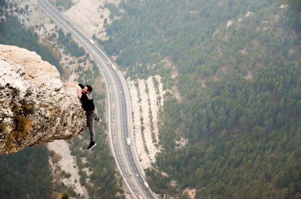 concepto de éxito de hombre de montaña en alta roca - extreme sports risk high up sport fotografías e imágenes de stock