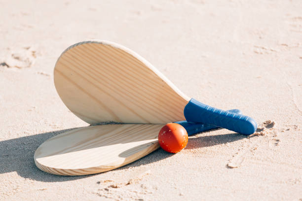 beach tennis, beach paddle ball, matkot. racchette da spiaggia e palla sulla spiaggia - matkot foto e immagini stock