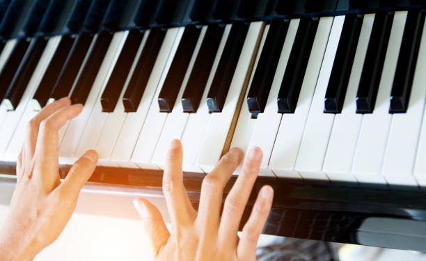 istock Woman hand playing the piano 879473656