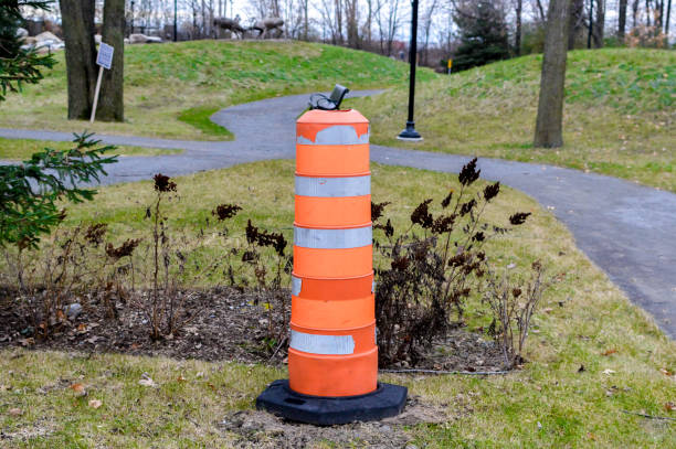 istock Bright orange and white traffic cone on a pavement in the public park 879505240