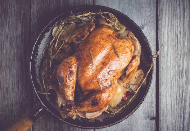 istock Roasted chicken in pan on the rustic wooden background 879507778