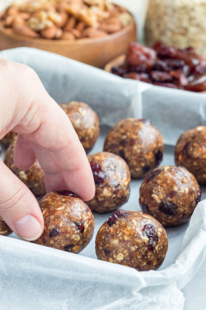 istock Healthy energy balls with cranberries, nuts, dates and rolled oats on tray, vertical 879515402