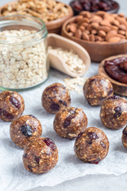 istock Healthy energy balls with cranberries, nuts, dates and rolled oats on parchment, vertical 879518714