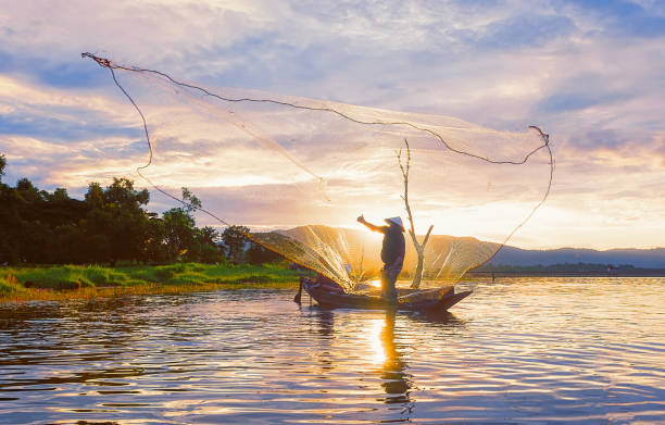 istock Fisherman on wooden boat. 879527014