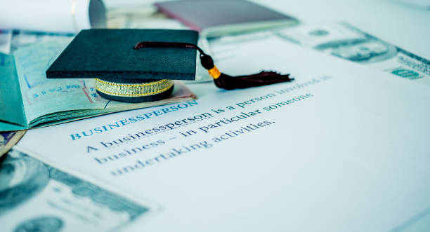 chapéu de formatura no livro passaporte e carta, empresário, o conceito de educação pós-graduação mba no exterior na universidade, requer muita divisas dólares para trazer sucesso na famosa instituição. - hallmark - fotografias e filmes do acervo