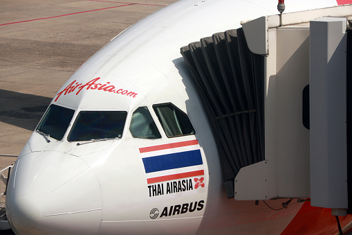 Don muang, Bangkok, Thailand, November 16, 2017 : Closeup in front of the plane of Thai Airasia x, Airbus A320  is parked against the passenger boarding dock gate.