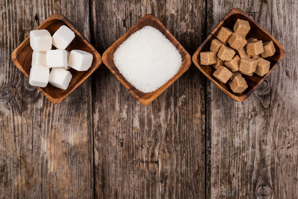 Three bowls with sugar Three bowls with sugar on an old wooden background, top view crystalline inclusion complex stock pictures, royalty-free photos & images