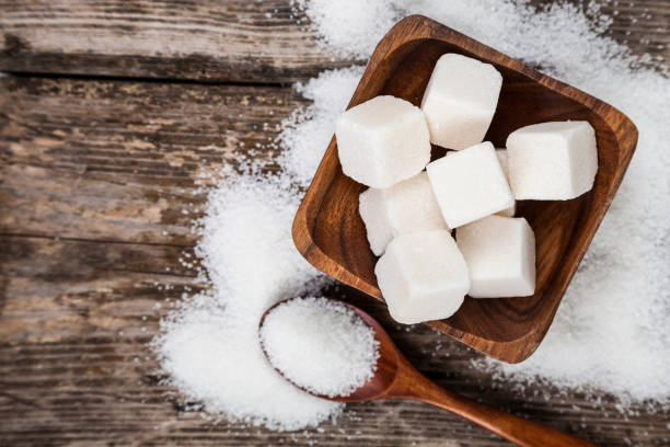istock Bowl with sugar and a wooden spoon 879557412