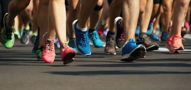 maratoneti che corrono su strada della città - corsa foto e immagini stock