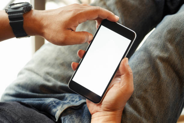 istock Over the shoulder view of person relaxing while using smartphone blank screen for graphics display montage. 879573440