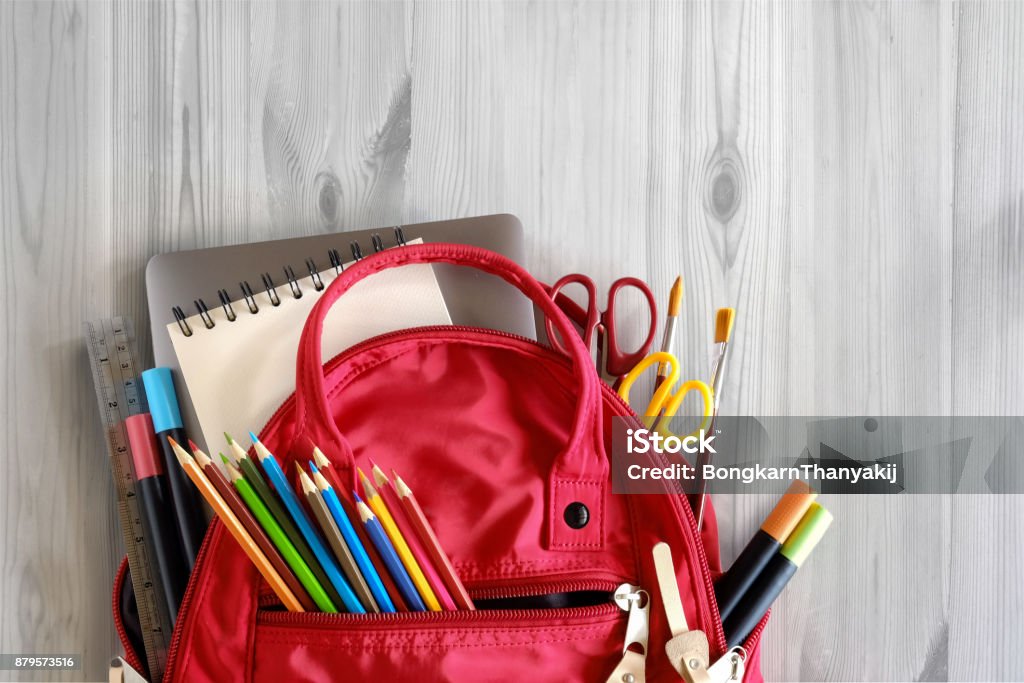 School backpack and school supplies on white wood table background. Back to school concept. School Building Stock Photo
