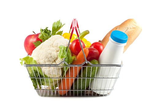 Shopping Concept: Perfect Shopping Cart Filled with  a Bottle of Milk, Baguette, Apple, Oranges, Celery, Cherry Tomatoes and Cauliflower on White Background