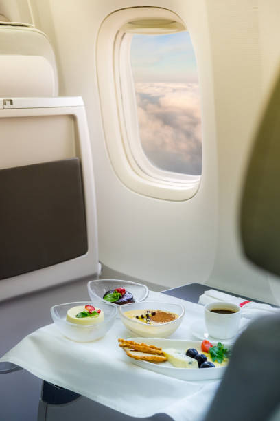 istock Cup of fresh coffee and dessert on table in airplane interior 879579002