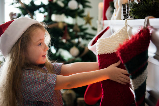 giovane ragazza caucasica che si gode le vacanze di natale - calza della befana foto e immagini stock