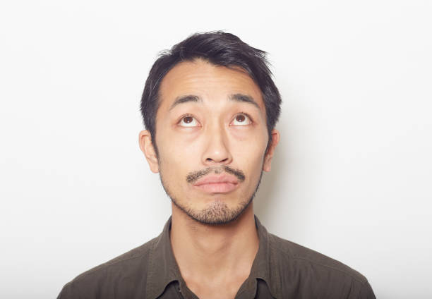 istock closeup face of young man with a beard looking up 879588884
