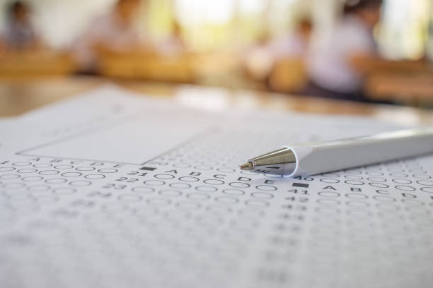 stylo de gros plan sur la forme optique de test standardisé avec réponses barboter pour feuille d’examen ou de réponse, le concept de l’éducation, mise au point sélective. - bubbled photos et images de collection