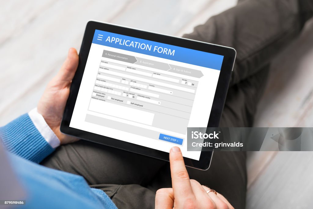 Sample application form on tablet computer Sample application form on tablet computer, man using tablet Application Form Stock Photo