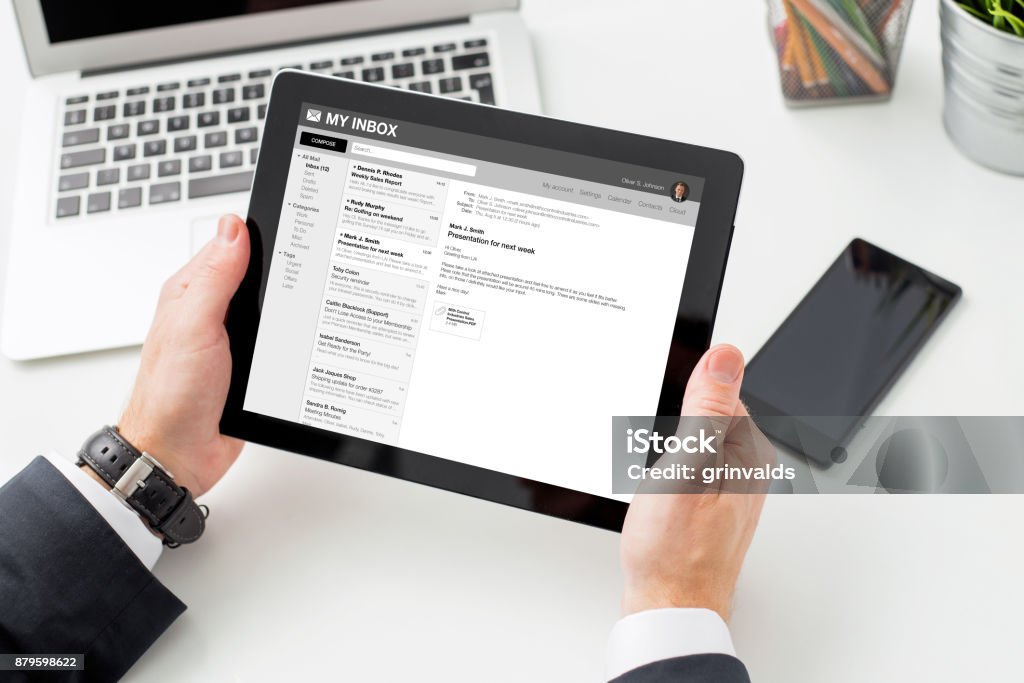 Businessman reading email on tablet computer. Businessman reading email on tablet computer, photo taken from above. E-Mail Stock Photo