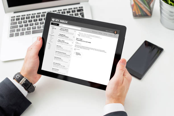 Businessman reading email on tablet computer. Businessman reading email on tablet computer, photo taken from above. e mail inbox stock pictures, royalty-free photos & images