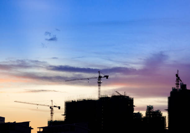istock Silhouette Construction site with cranes Against Cloudy Sky at Sunset 879603596